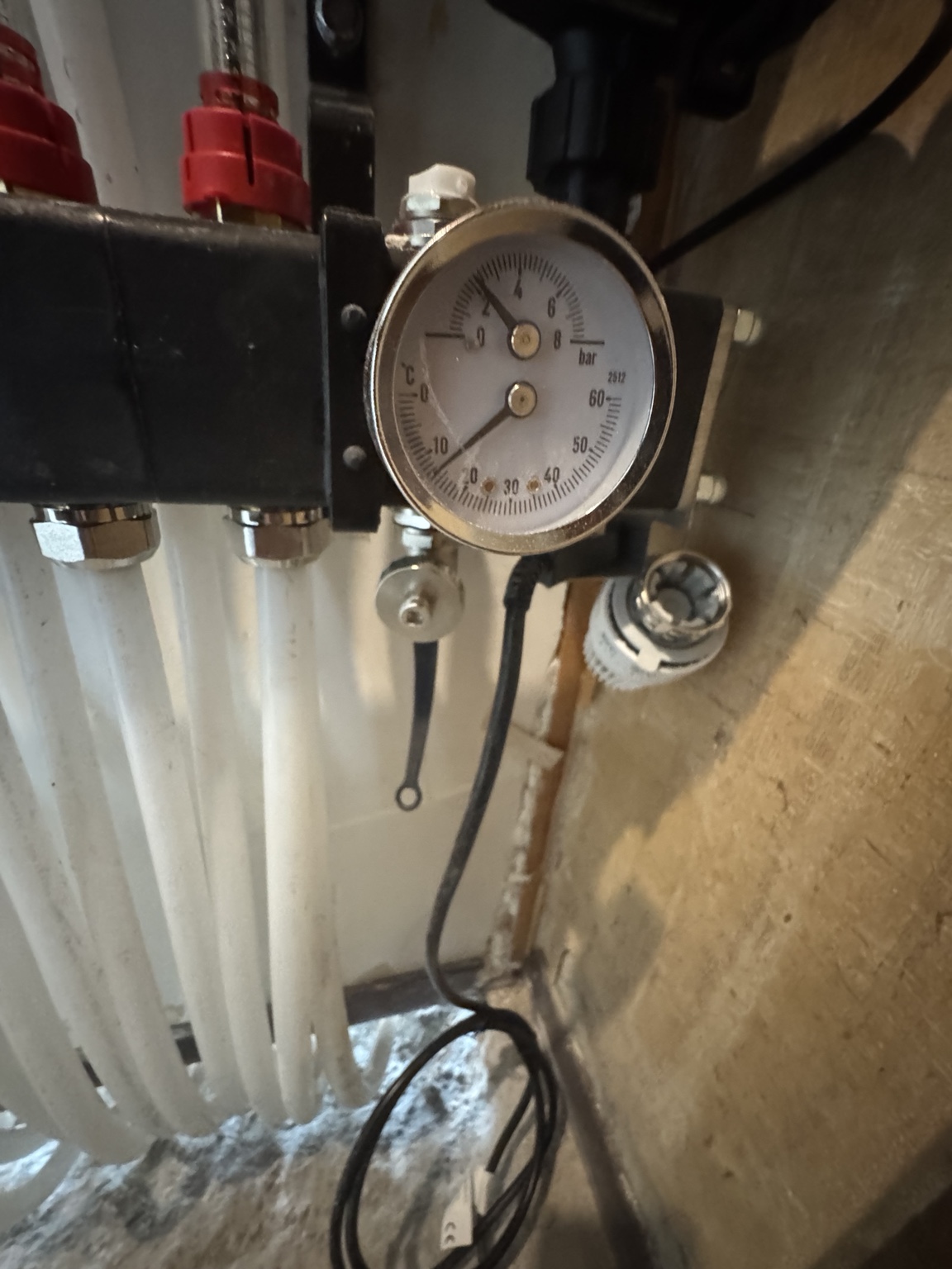 Detail van de vloerverwarmingsverdeler met manometer in Arnhem