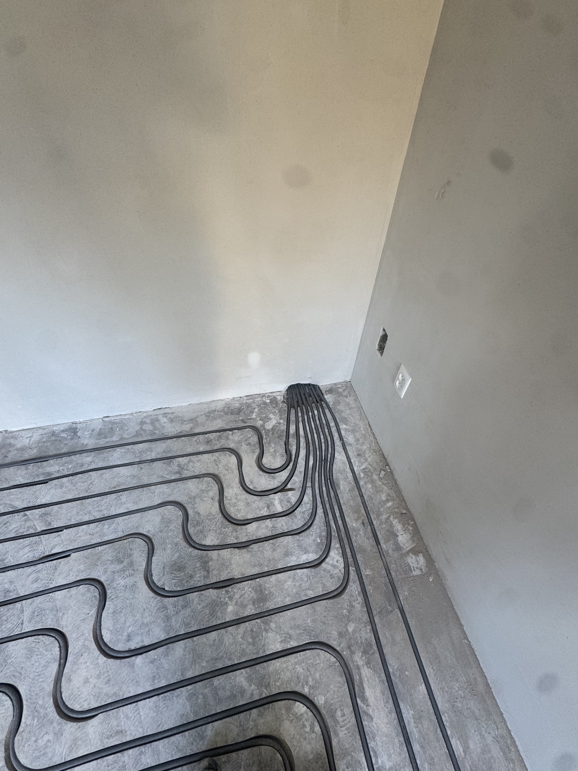 Vloerverwarmingsleidingen onder de muur door naar de verdeler in Doetinchem