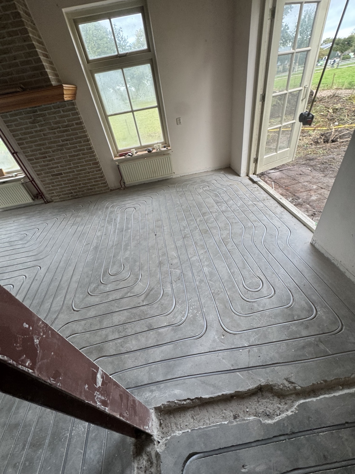 Vloerverwarmingsleidingen in de zandcementvloer bij de tuindeur in Heerenveen
